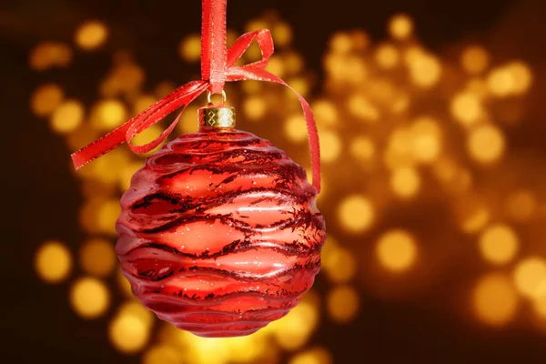 Palla di Natale rossa appesa al nastro con fiocco, su sfondo bokeh dorato con percorso di ritaglio. — Foto Stock