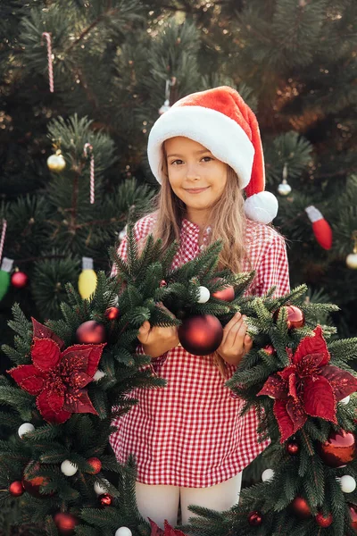 メリークリスマス。幸せな面白い子供たちの肖像画でサンタ帽子とともにクリスマスリース. — ストック写真