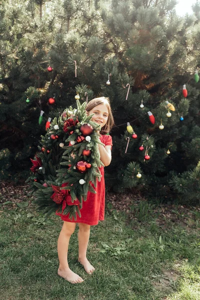 Frohe Weihnachten. Porträt von fröhlichen lustigen Kindermädchen mit Weihnachtsmütze und Weihnachtskranz. — Stockfoto
