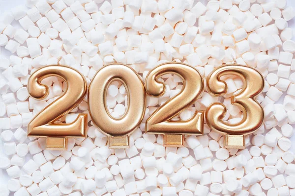 Sfondo vacanza Felice anno nuovo 2023. Numeri dell'anno 2023 realizzati da candele d'oro su sfondo di marshmallow bianco. — Foto Stock