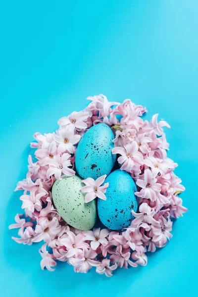 Osterhintergrund mit blauen Ostereiern im Nest der Frühlingsblumen. Draufsicht mit Kopierraum. Frohe Ostern Frühling Festliche Grußkarte. Feiertagsregelung. — Stockfoto