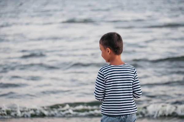 海岸を走っている子供。夏休みだ。幸せな子供は日没時にビーチで遊んでいます — ストック写真