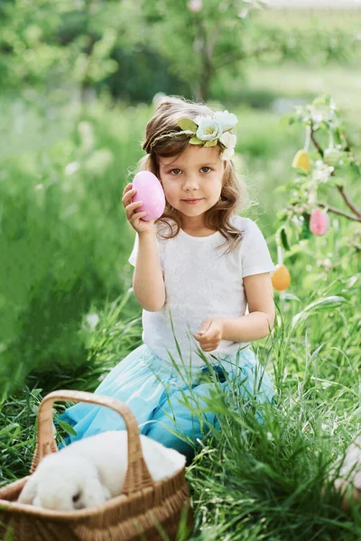 Baby with basket full of colorful eggs. Easter egg hunt. — Stock Photo, Image