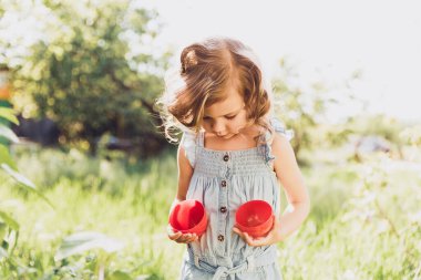 Sepeti renkli yumurtalarla dolu bir bebek. Paskalya yumurtası avı.