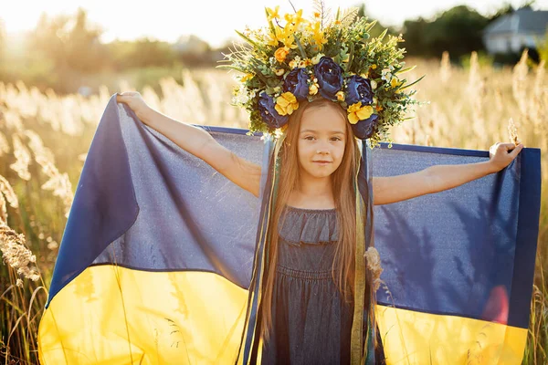 Дівчинка несе літаючий синій і жовтий прапор України в полі. — стокове фото