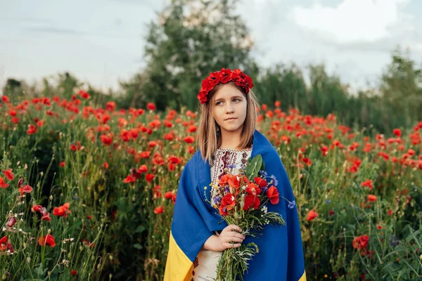 女の子はフィールドでウクライナのなびかせ青と黄色のフラグを運ぶ. — ストック写真