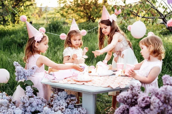 Летняя вечеринка в честь дня рождения детей. Группа счастливых детей, празднующих день рождения в парке. — стоковое фото