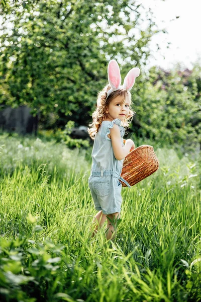Dítě s košíkem plným barevných vajec. Velikonoční hon na vejce. — Stock fotografie