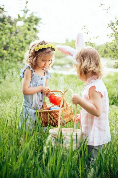 Group Of Children Wearing Bunny Ears Running To Pick Up colorful Egg On Easter Egg Hunt In Garden — Stok Foto