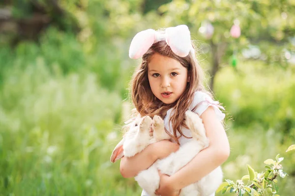 Baby with basket full of colorful eggs. Easter egg hunt. — Stock Photo, Image