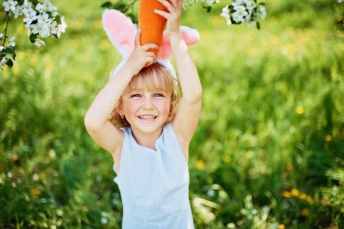 Sepeti renkli yumurtalarla dolu bir bebek. Paskalya yumurtası avı.