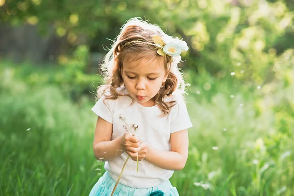 Girl blowing dandelions flower selective focus. Allergy season. — Stock Photo, Image