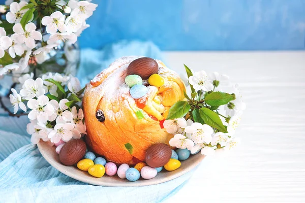 Kue mangkuk tradisional kue Paskah kraffin dengan kismis di latar belakang biru. — Stok Foto