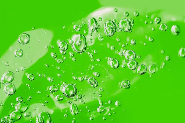 Närbild makro Aloe vera gel kosmetisk konsistens grön bakgrund med bubblor. — Stockfoto