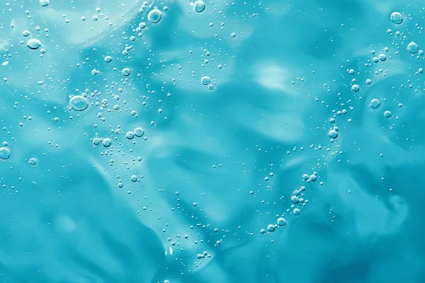 Tutup makro Aloe vera gel latar belakang kosmetik biru dengan gelembung. Stok Foto Bebas Royalti
