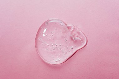 Close up macro Aloe vera gel serum cosmetic texture on pink background with bubbles.