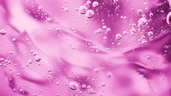 Tutup makro Aloe vera gel latar belakang tekstur kosmetik merah muda dengan gelembung. Stok Gambar Bebas Royalti
