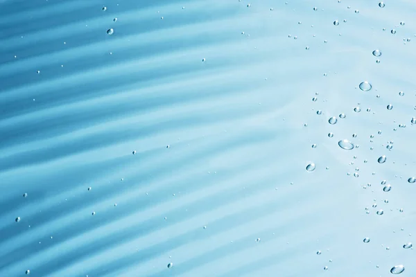 Tutup makro Aloe vera gel latar belakang kosmetik biru dengan gelembung. Stok Gambar