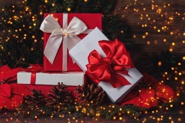 Noel tatili arka planında ışıl ışıl dekorasyon ve hediye kutuları ahşap tahtada.