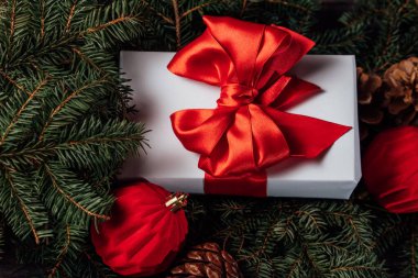 Noel tatili arka planında, dekorasyonlar ve hediye kutuları ile ahşap tahtada ışıl ışıl parlıyor. Yeni yılı kutluyoruz, yakın plan. Kırmızı kurdele ve ladin dalı. Kış Xmas tatil teması.