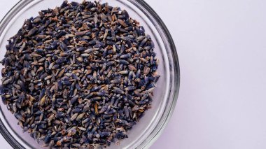 Menekşe arkaplanda bir tabak kurutulmuş lavanta. Davetiye, spa, tarif konsepti. Üst görünüm, yakın çekim, düz döşeme, kopyalama alanı, tasarım. Ev spası. Aromaterapi. Alternatif tıp.