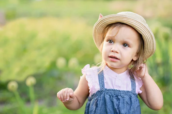 屋外でエンドウ豆のポッドを食べる子供の少女の肖像画 庭の夏にエンドウ豆を収穫する女の子 子供のために食べるなんて 小さな農家の子供野菜を選んだ素敵な女の子 — ストック写真