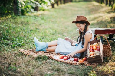 Apple Orchard'da Apple'lı kız. Güzel Kız Orchard Organik Elma Yeme. Hasat Konsepti. Bahçe, Bebek sonbahar hasat meyve yeme.