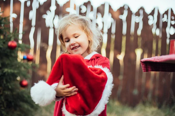 7月のクリスマス 子供は夏に木でクリスマスを待っています クリスマスツリーを飾る赤いドレスの少女の肖像画 冬休みや人の概念です メリークリスマスとハッピーホリデー — ストック写真