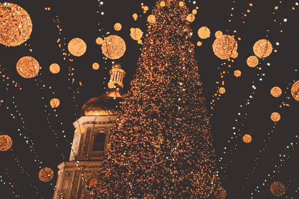 Hafif bokeh odaklanmış arkaplan. Kyiv Ana Noel ağacı ışıklarının bulanık fotoğrafı. Altın ışık efektleri. tatiller, arka plan ve aydınlatma kavramı