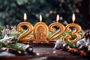 Tatil geçmişi. Mutlu yıllar 2023. 2023 yılının sayıları Bokeh şenlik ışıl ışıl arka planında yanan altın mumlar tarafından yapıldı. Yeni yılı kutluyoruz, yakın plan. Metin için boşluk