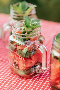 Karpuz ve nane arınma suyu. Buzlu limonata ve nane şekeri kavanozlardaki yaz ferahlatıcı içecek gibi. Meyveli soğuk meşrubat. Kırmızı yaz suyunu tazeliyorum.