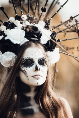 Calavera Catrina 'nın siyah elbiseli portresi. Şeker kafa makyajı. Dia de los muertos. Ölüler Günü. Cadılar Bayramı.