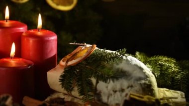 Tahta arka planda dört yanan kırmızı renkli çelenk süslemesi. Noel 'den önceki bir gelenek. Stollen Geleneksel Yılbaşı Alman tatlısını parçalara ayırdı.