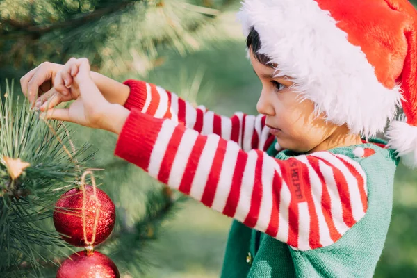 Christmas in july. Child waiting for Christmas in wood in summer. portrait of boy decorating christmas tree. winter holidays and people concept. Merry Christmas and Happy Holidays