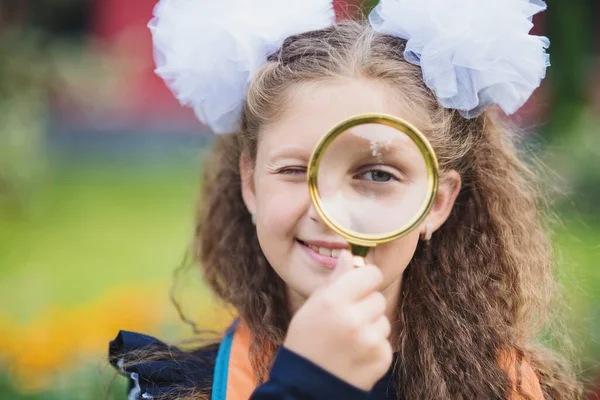 Portrait Beautiful Young Schoolgirl Looking Magnifying Glass Sitting Desk Background — Stok fotoğraf