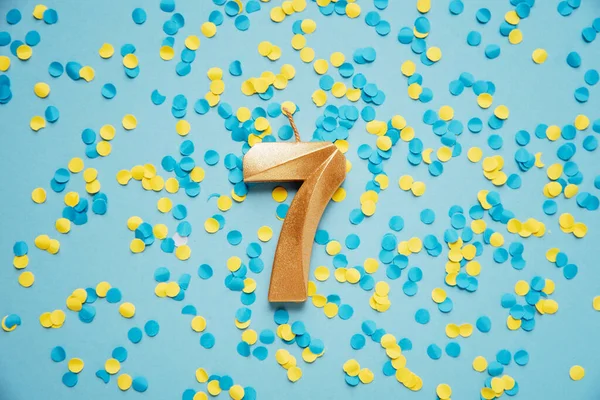 Number Seven Golden Celebration Birthday Candle Yellow Blue Confetti Background — 图库照片