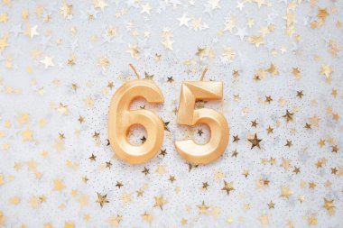 Number 65 sixty five golden celebration birthday candle on Festive Background. sixty five years birthday. concept of celebrating birthday, anniversary, important date, holiday
