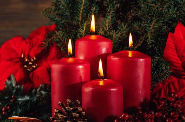 Tahta arka planda dört yanan kırmızı renkli çelenk süslemesi. Noel 'den önceki bir gelenek. Noel arkaplan kavramlı xmas ışıkları. Şenlikli natürmort.