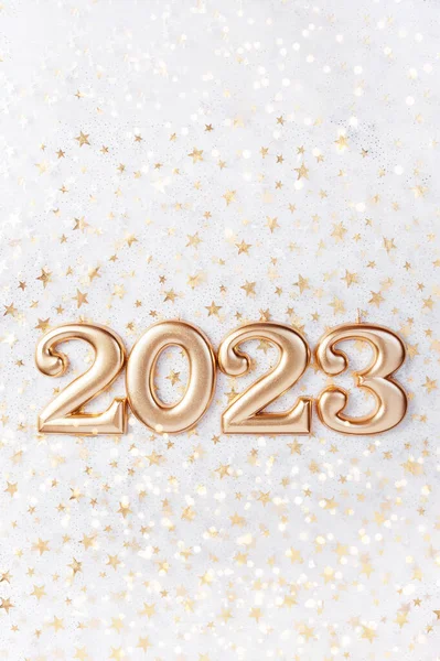 Holiday background Happy New Year 2023. Numbers of year 2023 made by gold candles on bokeh festive sparkling background. celebrating New Year holiday, close-up. Space for text