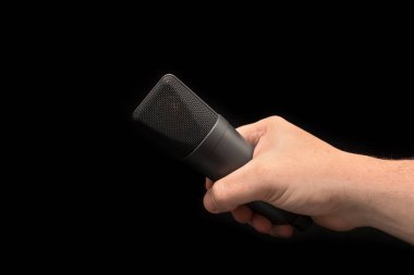 Mikrofon yakın el mikrofonu yukarı. Siyah arka plan üzerine