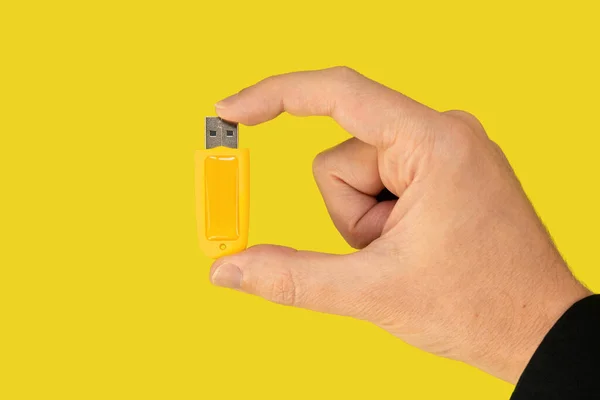 USB tükenmezkalem götürmek üstünde el ile izole sarı arka plan sarı. Önden Görünüm