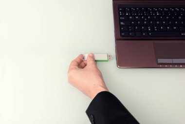Laptop bilgisayarında elle bağlı USB bellek. Zenital görünüm