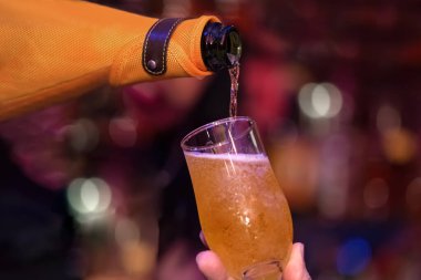 Müşteriye bir bardak şampanya servisi. Şişe ve cam yakın plan.