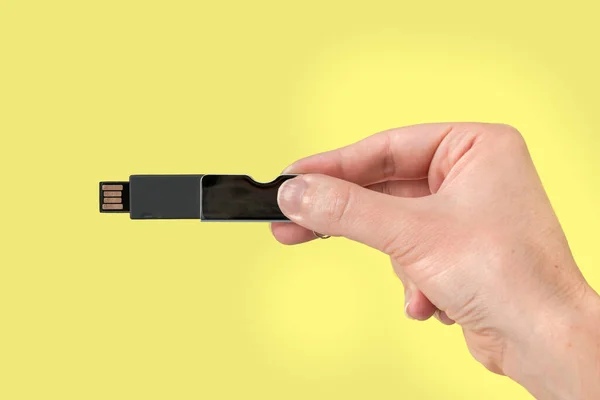 Black Usb Pen Drive Hand Isolated Yellow Background Front View — Zdjęcie stockowe