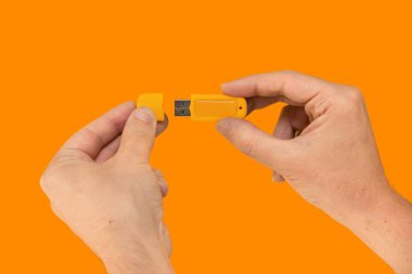 Sarı USB flaş bellek ve izole turuncu arka plan. Ön görünüm