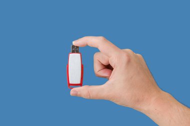 Elimizde mavi arka planlı kırmızı USB flaş bellek var. Ön görünüm