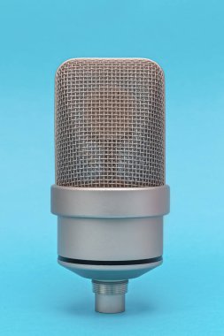 Profesyonel büyük diyafram yoğunlaştırıcılı, mavi arka planlı mikrofona yakın çekim. Ön manzara, makro