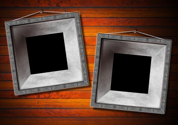 Twee metalen frame op een oude houten muur — Stockfoto