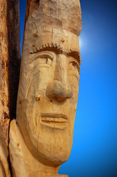 Cara esculpida em tronco de árvore — Fotografia de Stock
