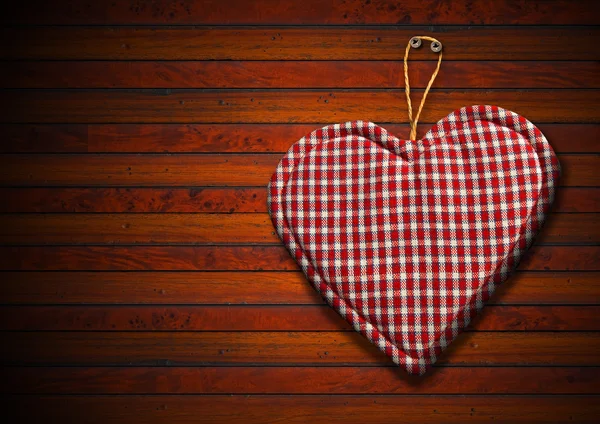 Corazón de tela sobre fondo de madera marrón — Foto de Stock